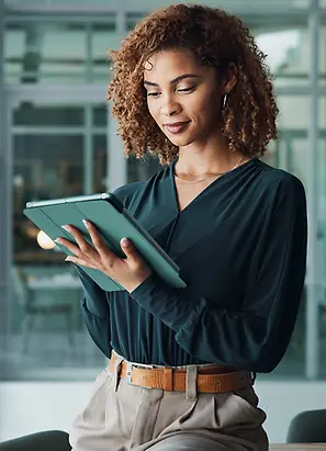 Female office worker in office accessing data on tablet