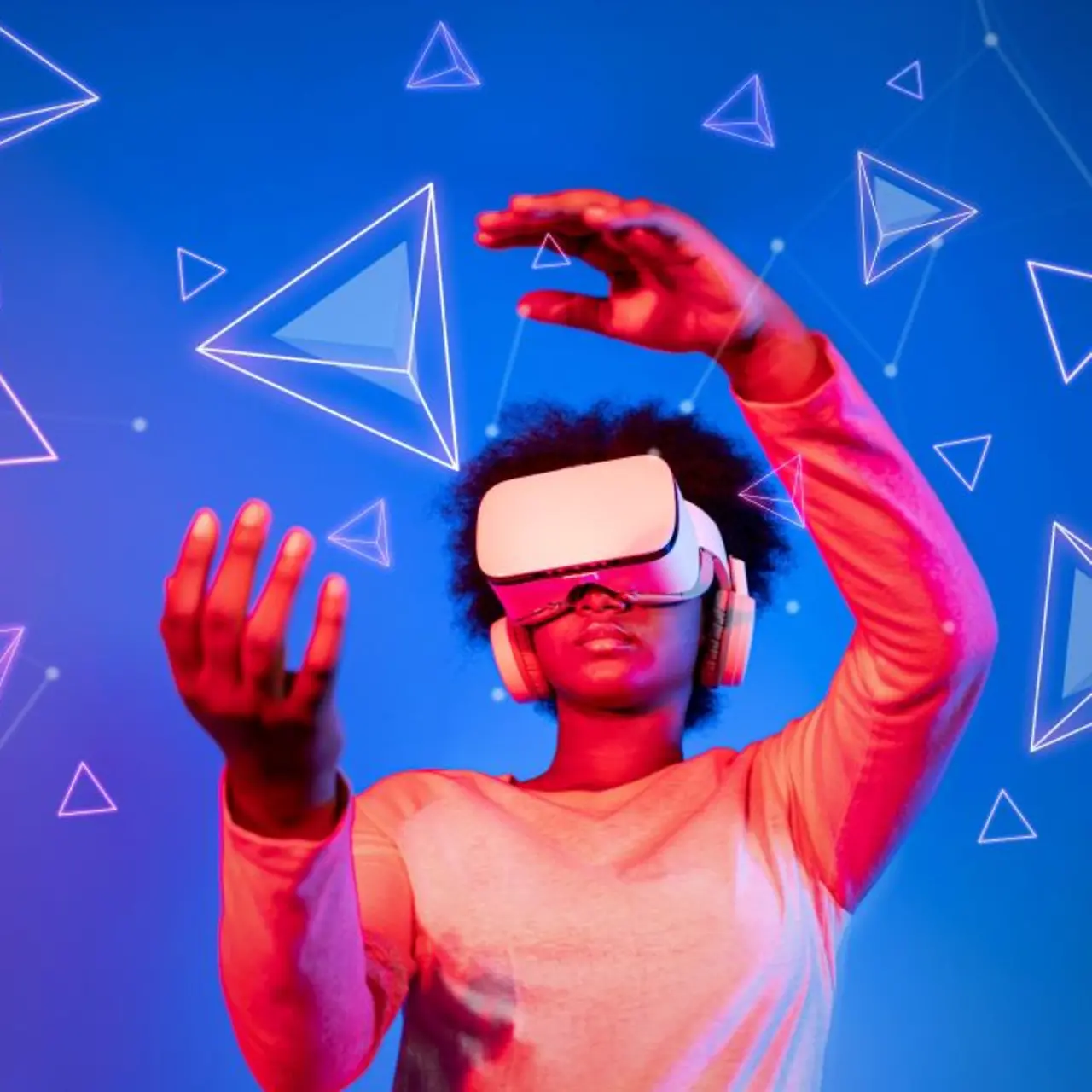 African woman with VR glasses standing at blue and pink background and looking at floating geometric shape