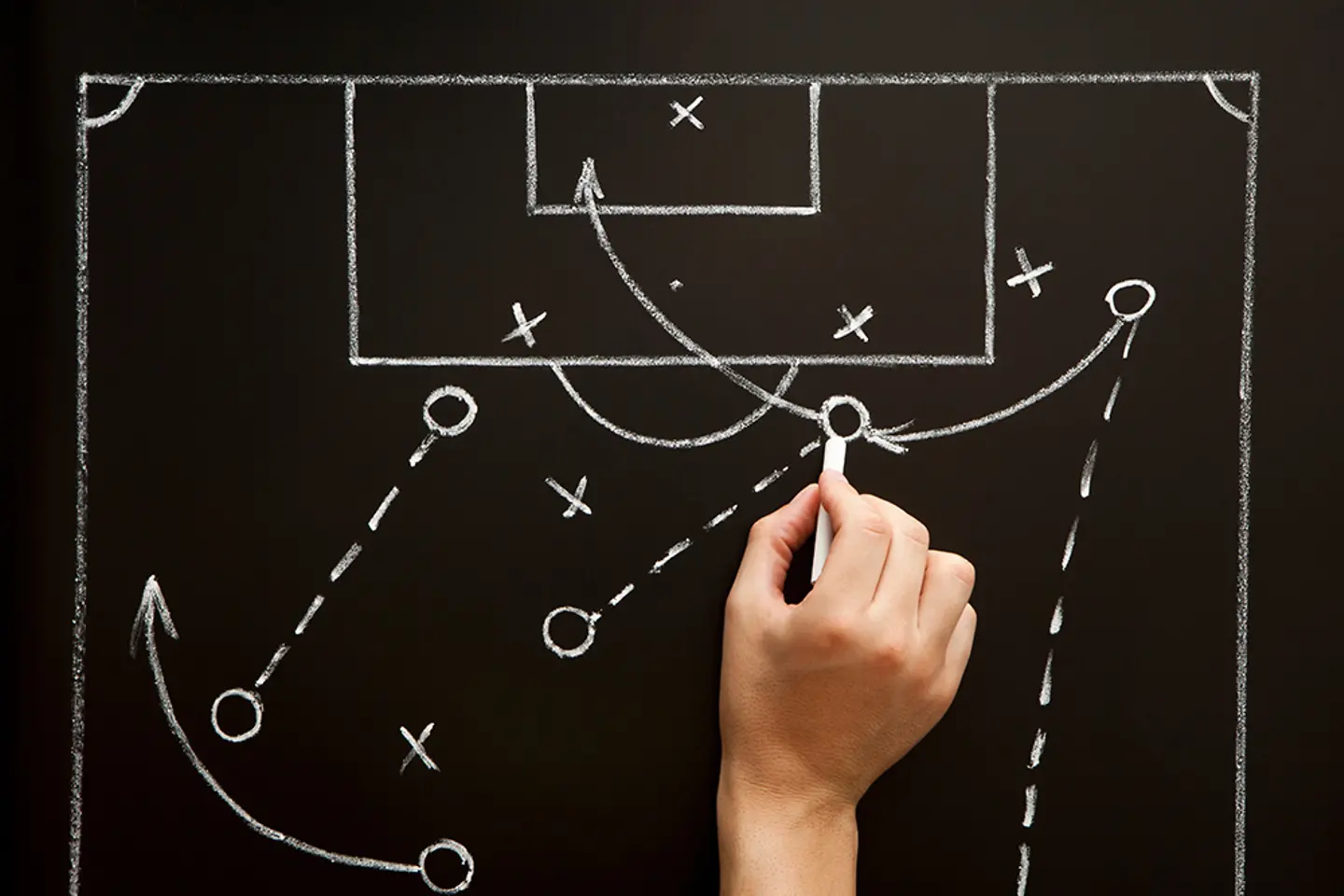 A coach devises a strategy for a soccer match in the changing room.