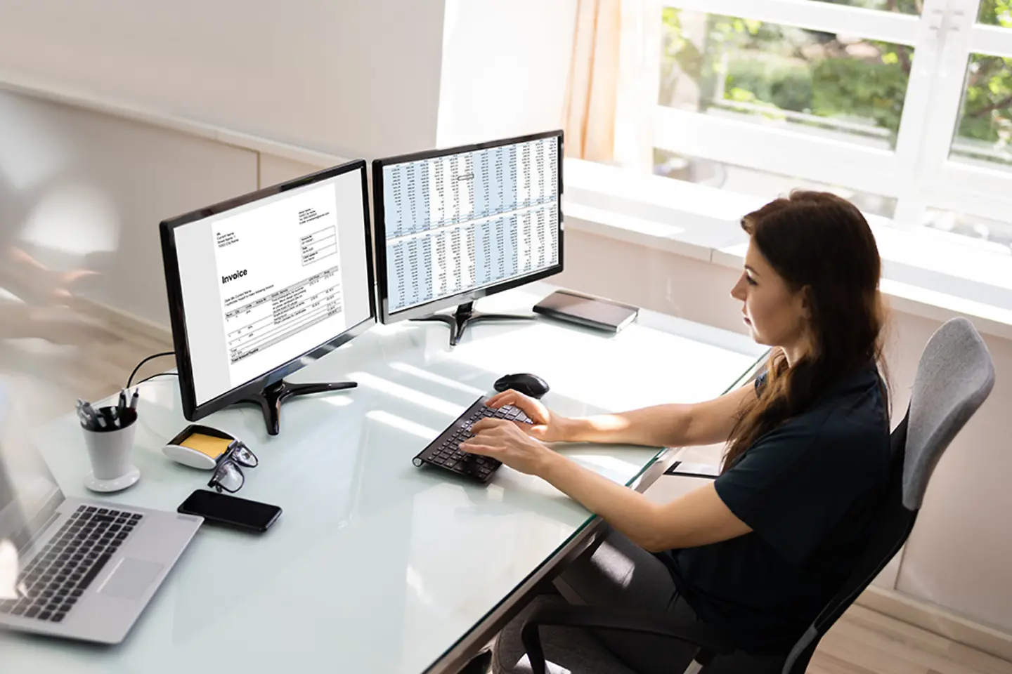 Une comptable utilise un logiciel de facturation électronique sur un ordinateur de bureau