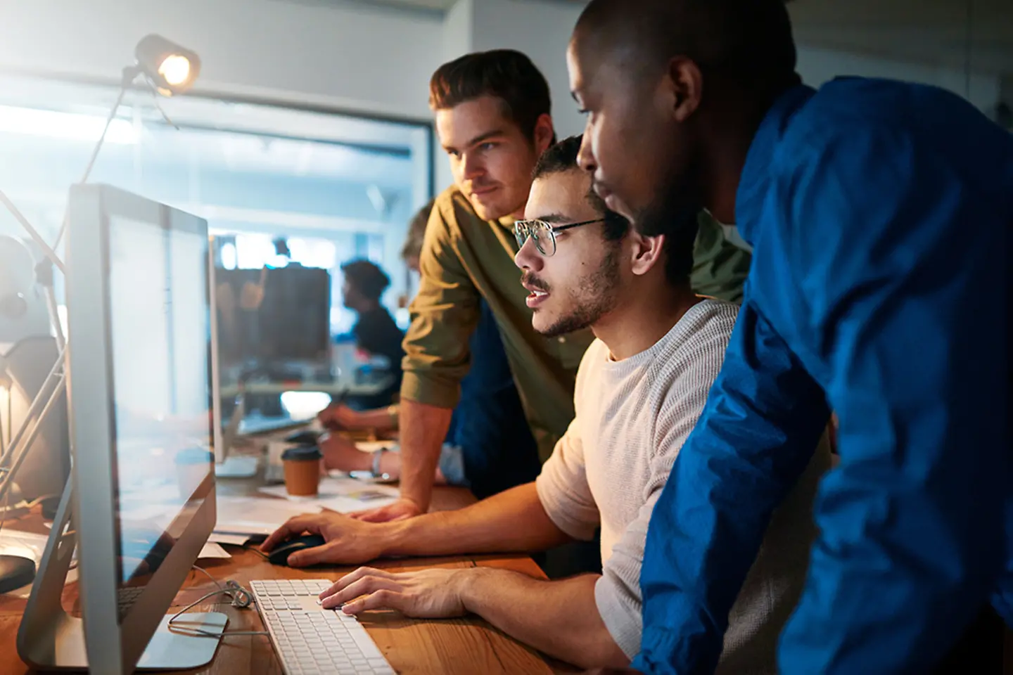 Leden van een IT-ondersteuningsteam praten aan een tafel.