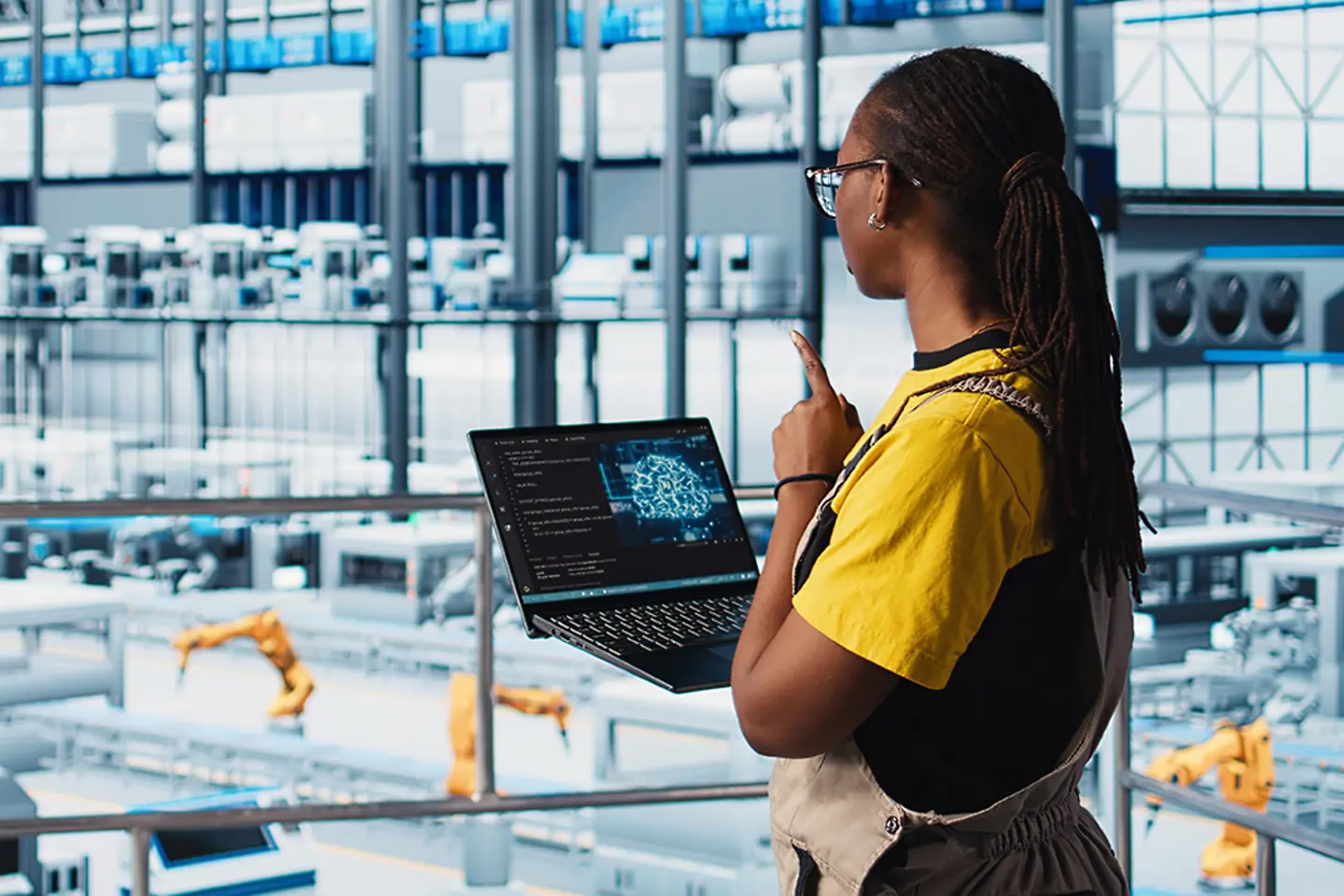 Ingenieurin in einer intelligenten Fabrik nutzt Augmented Reality, um Daten auf einem Laptop zu erfassen.