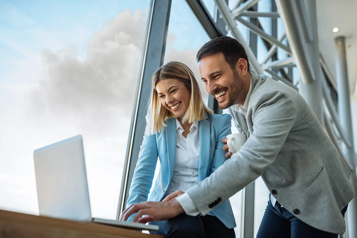 Zwei lachende Mitarbeiter im Gespräch, wir kennen keine Grenzen