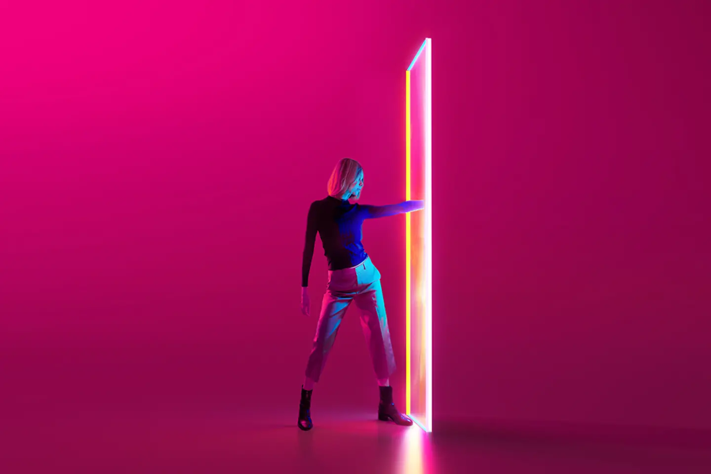 Digital generiertes Bild einer jungen Frau vor rotem Hintergrund, die eine Hand durch ein bunt leuchtendes Portal steckt.