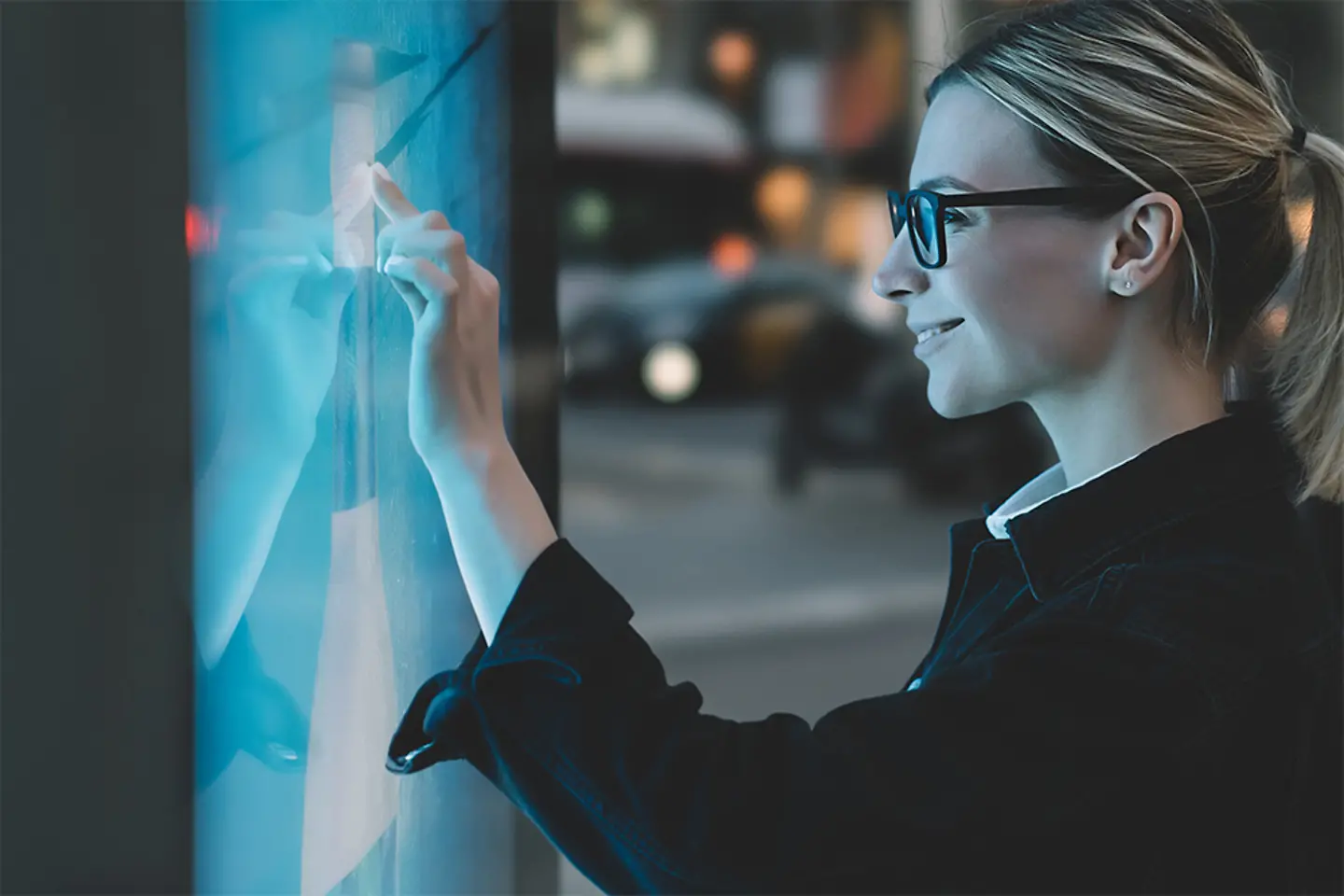 Junge Frau berührt Touchscreen mit dem Finger