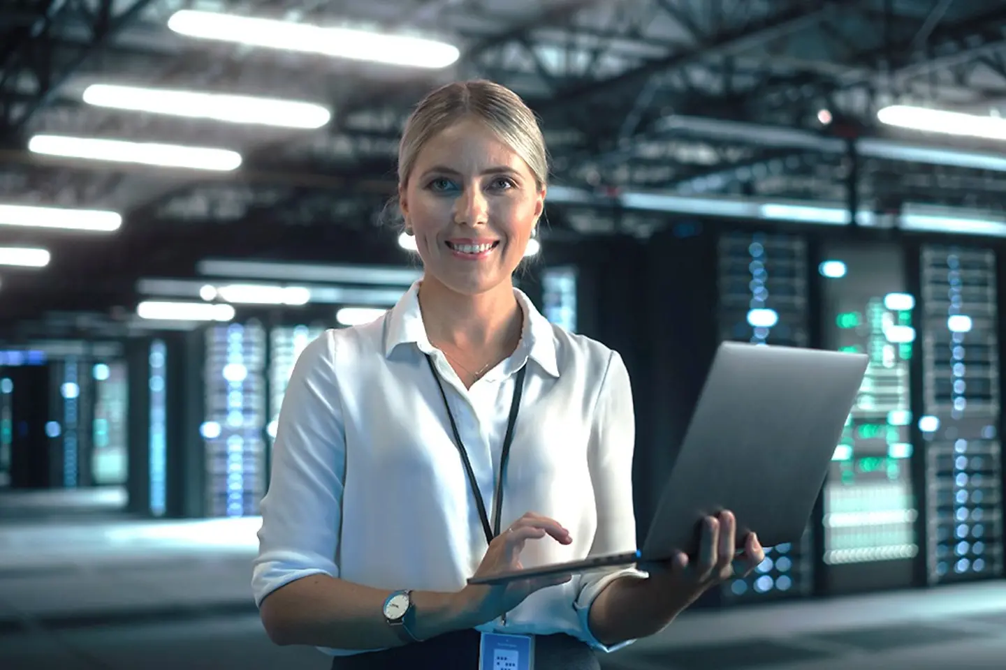 Eine Cloud-Expertin überprüft Daten auf einem Laptop im Rechenzentrum