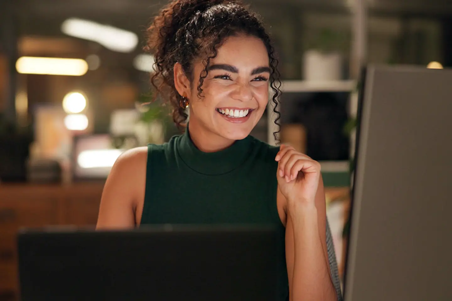 Happy young woman in front of computer