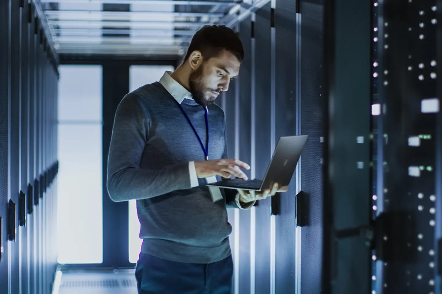 Un informaticien avec un ordinateur portable dans une salle de serveurs
