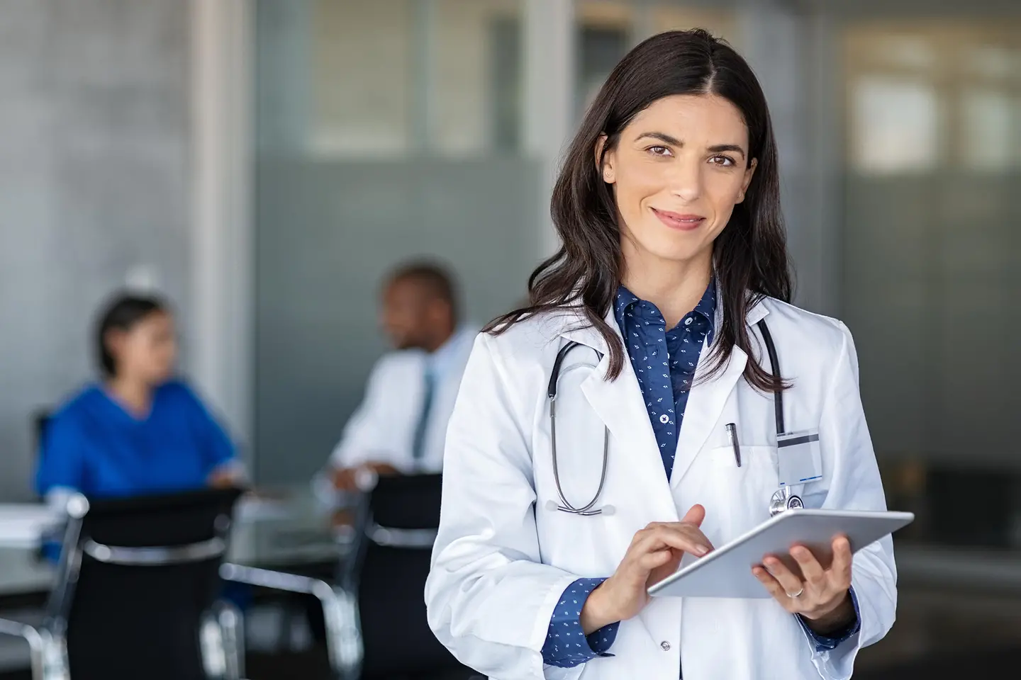 Profesional médica con tablet en una sala de reuniones