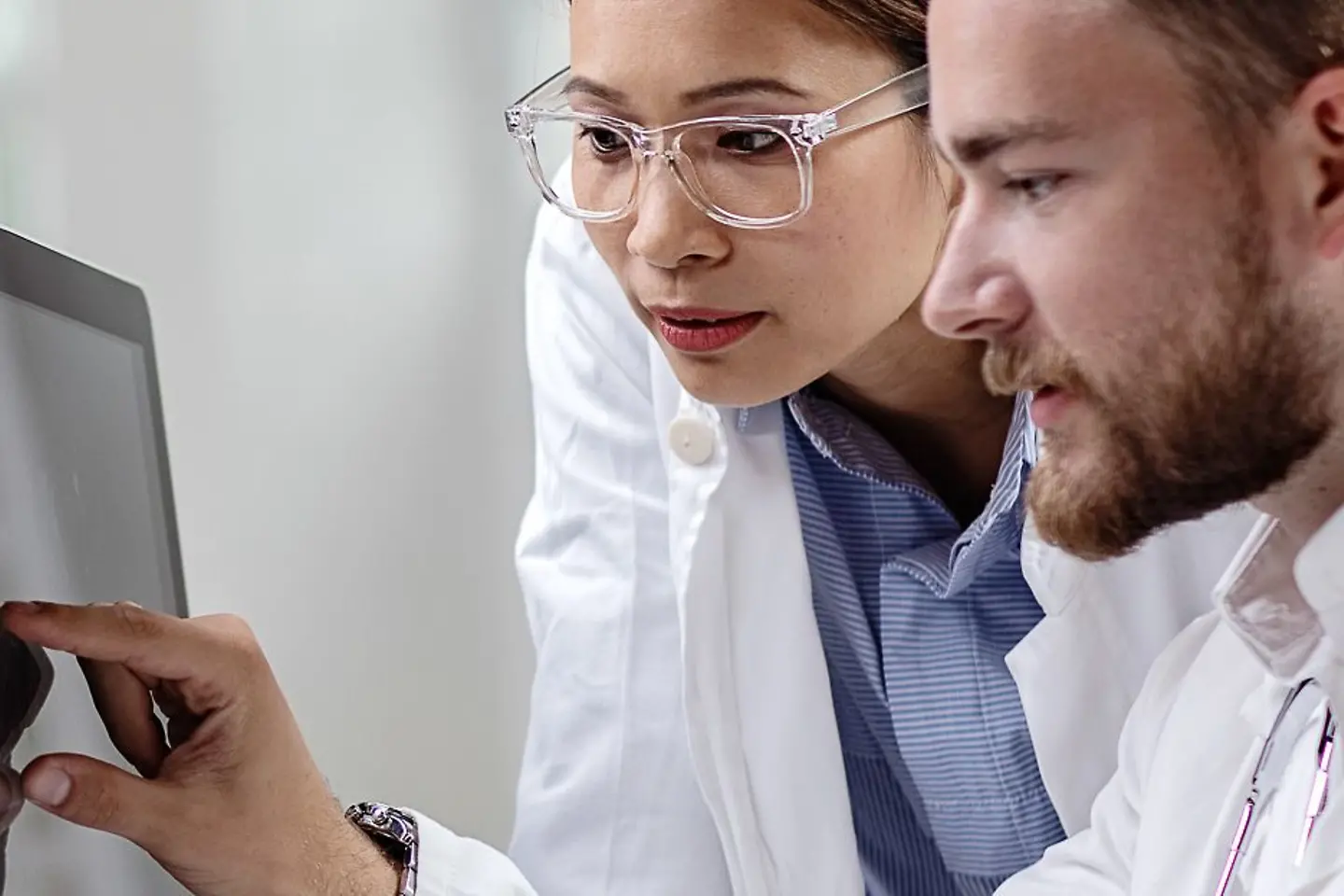 Two doctors analyze data on a screen