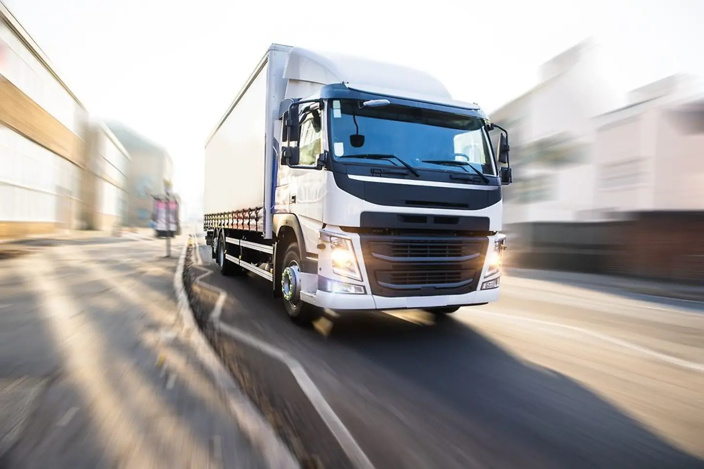 Un camión blanco cruzando una ciudad.