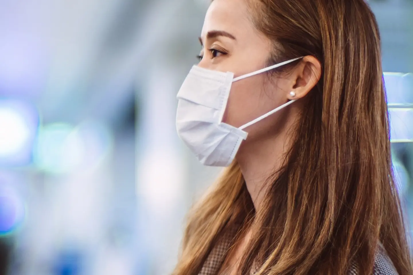 Een vrouw met een mondkapje staat op een station.