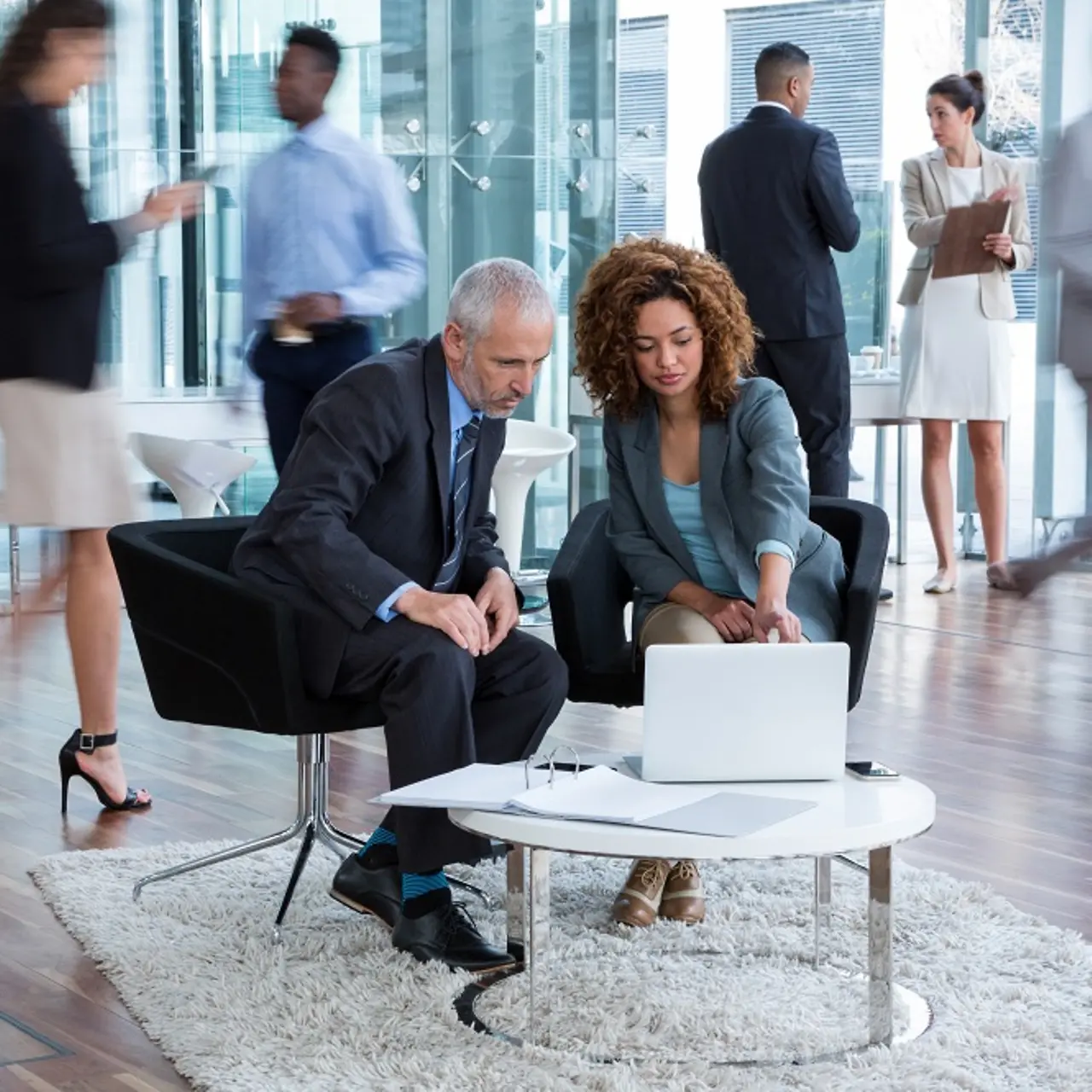 Empresários discutem a transformação de dados em uma mesa com um laptop