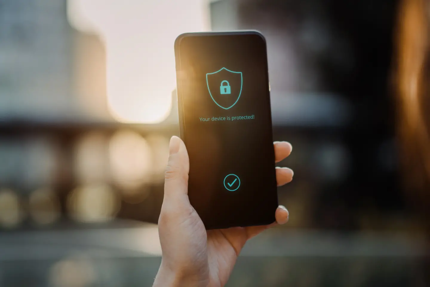 Mano sujetando un smartphone con un candado de seguridad en la pantalla