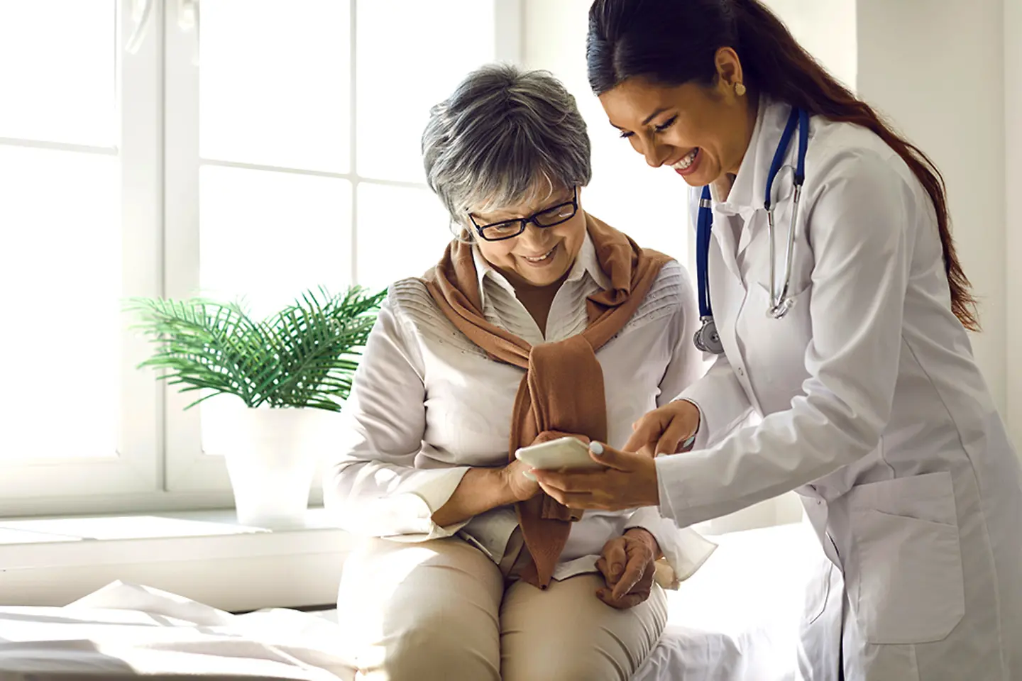 Arzt und Patient verwenden die Epic-Cloud-basierte Gesundheitslösung auf einem Mobiltelefon